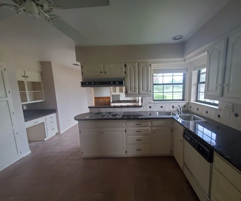 Kitchen with white cabinets and dark countertops in Gainesville, Texas